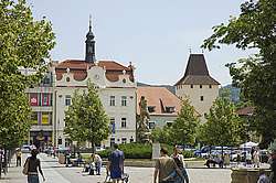 Husovo náměstí s&nbsp;radnicí, v&nbsp;pozadí městská brána